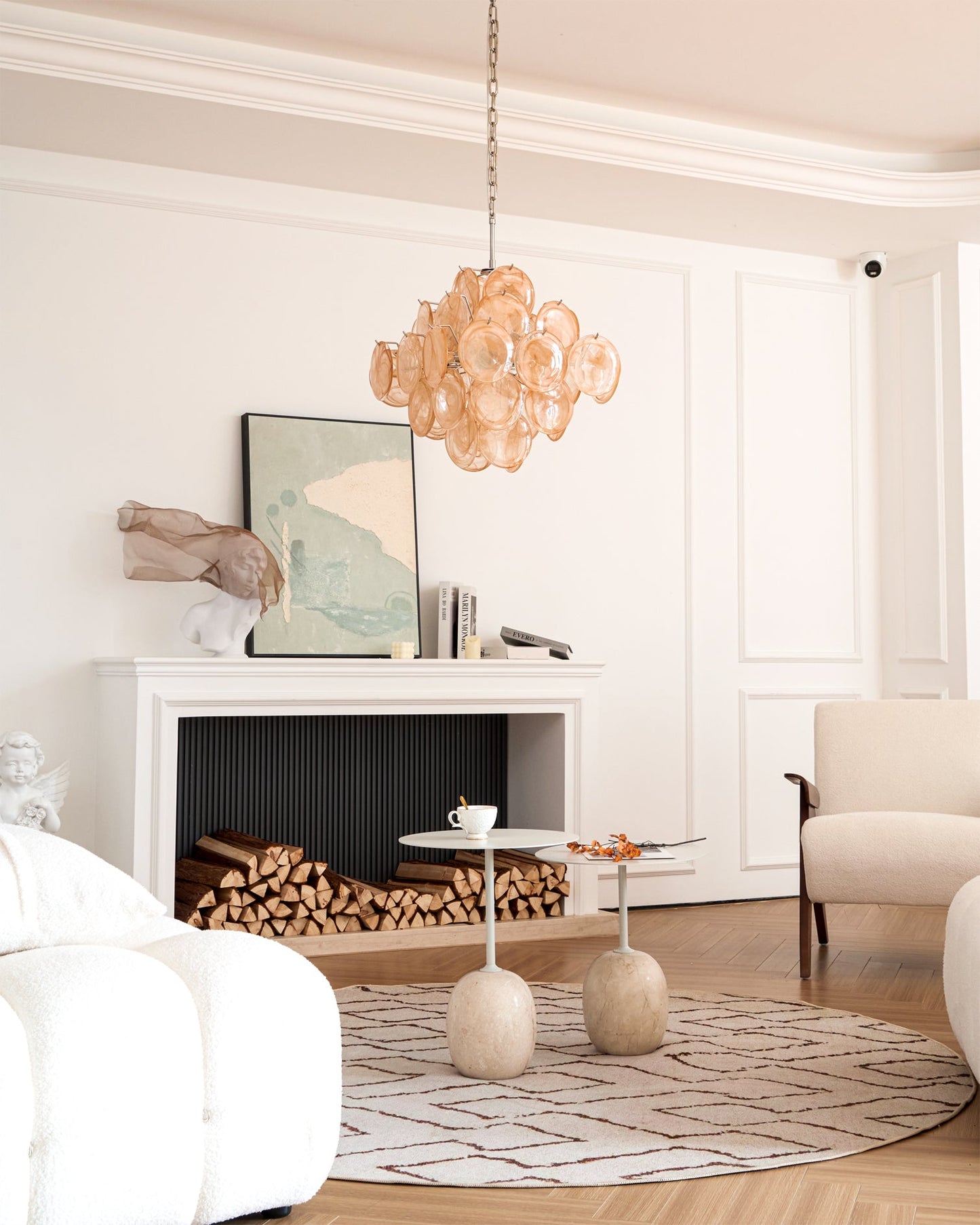 Modern living room with a chandelier, fireplace, and white furniture.