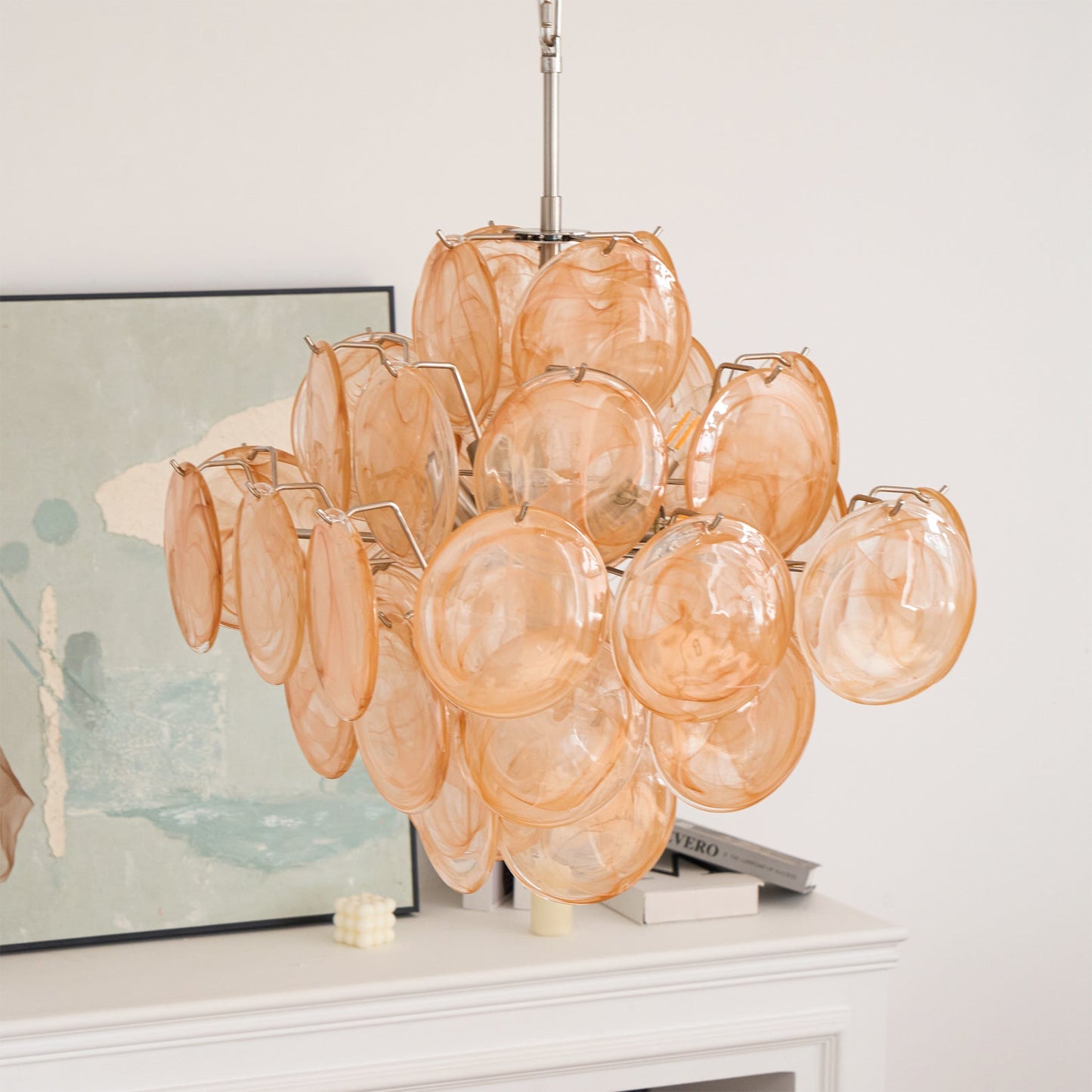 Chandelier with orange glass shades on a white surface with a light background