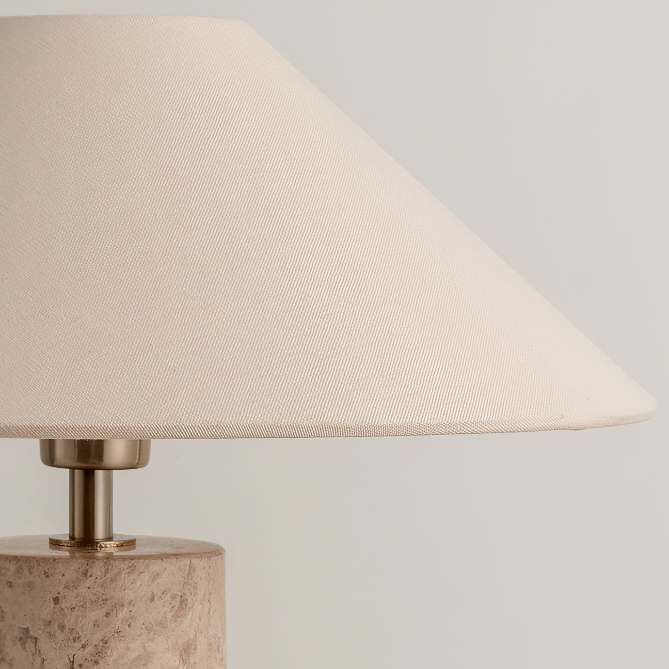 Table lamp with beige fabric shade and marble base on a neutral background