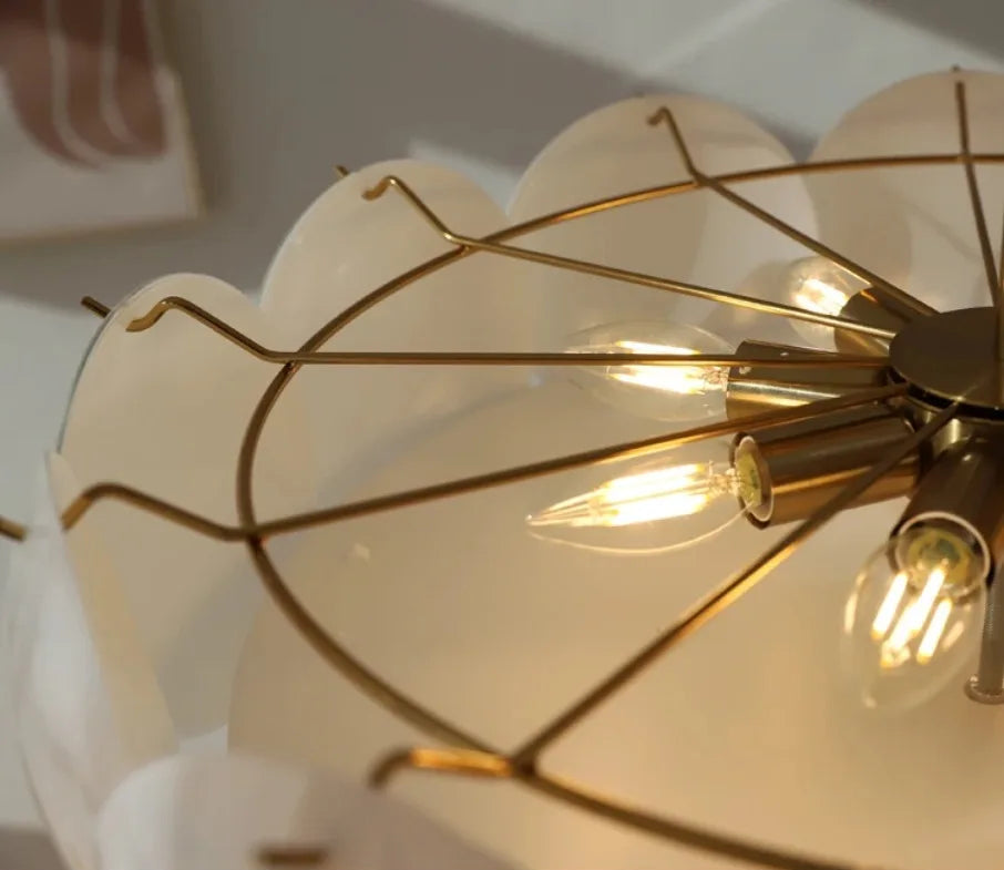 Close-up of a decorative light fixture with gold metalwork and glass shades.