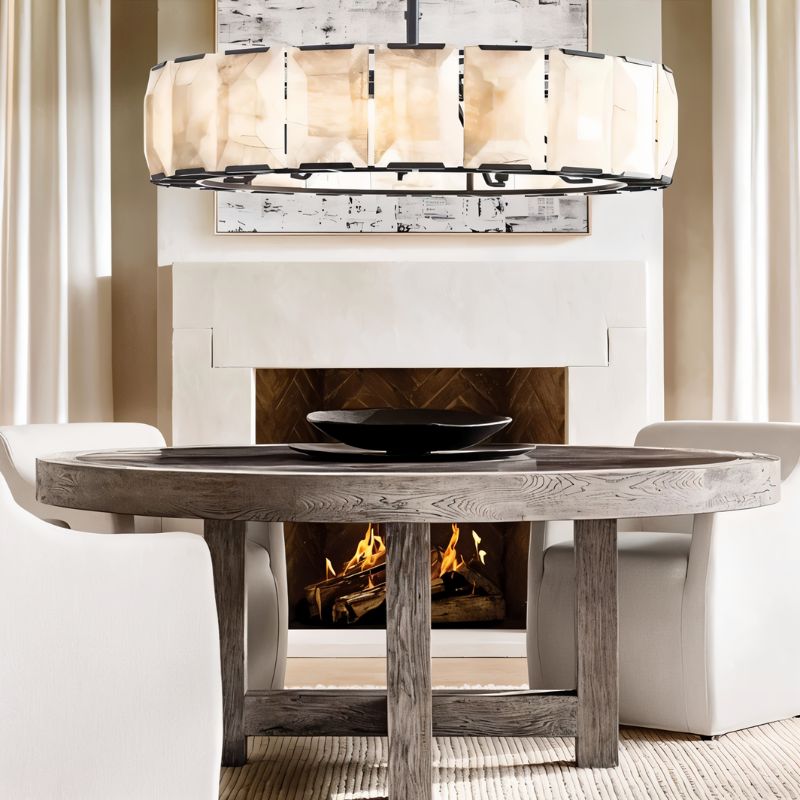 Dining room with a round wooden table, chandelier, and fireplace.