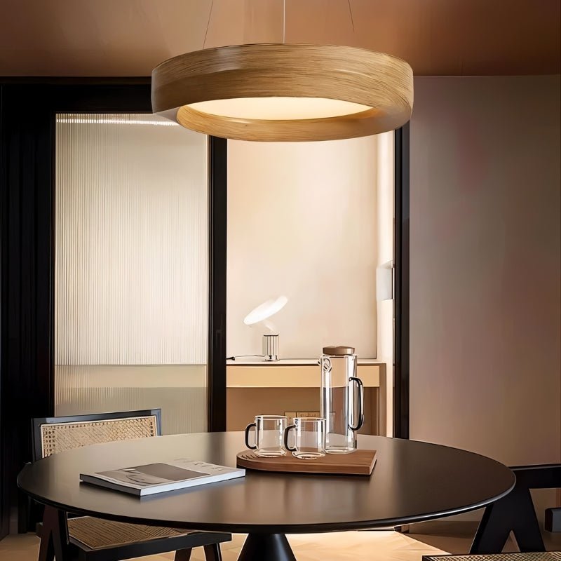 Modern dining room with round table, chairs, and a pendant light.