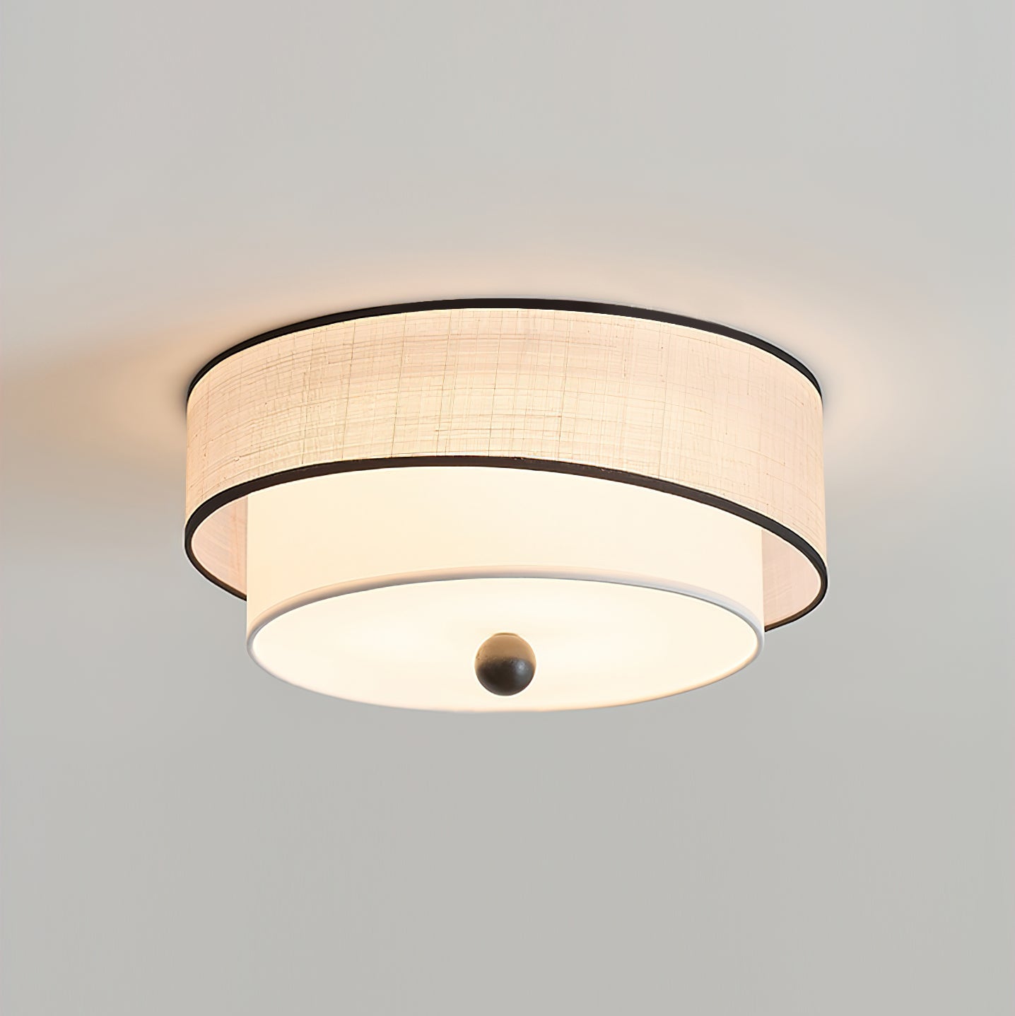 Ceiling light fixture with fabric shade on a plain background