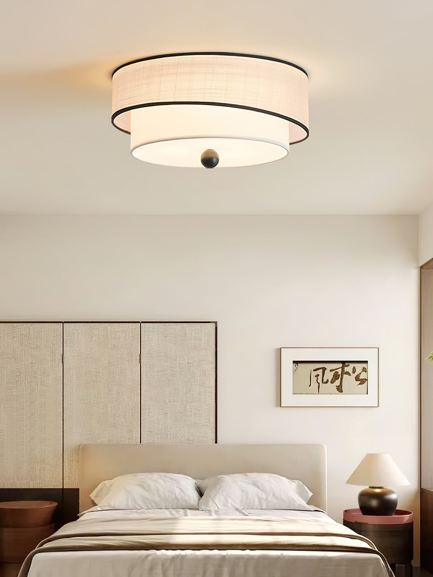 Modern bedroom with a ceiling light fixture, bed, and wall art.