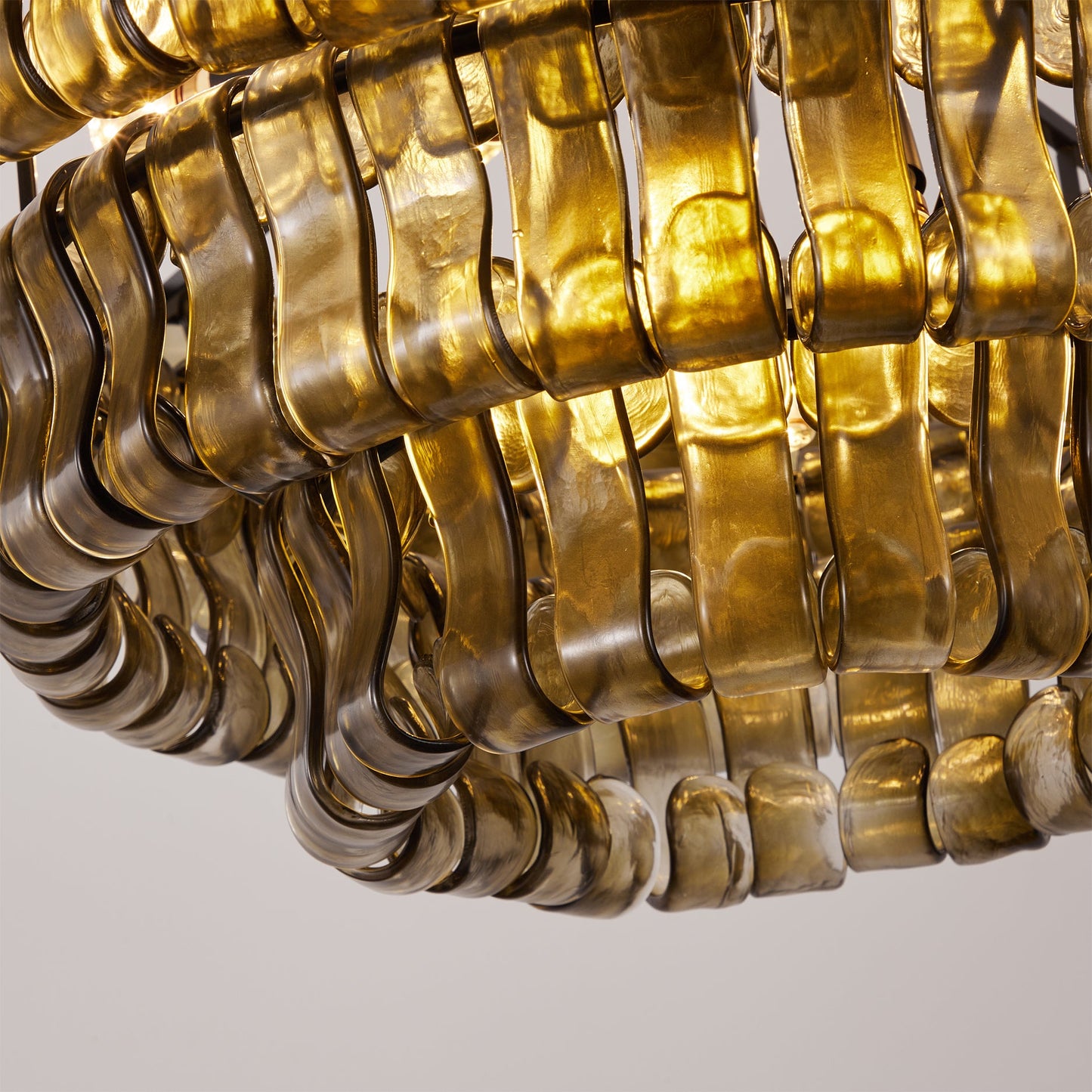 Close-up of a gold chain-like chandelier on a light gray background