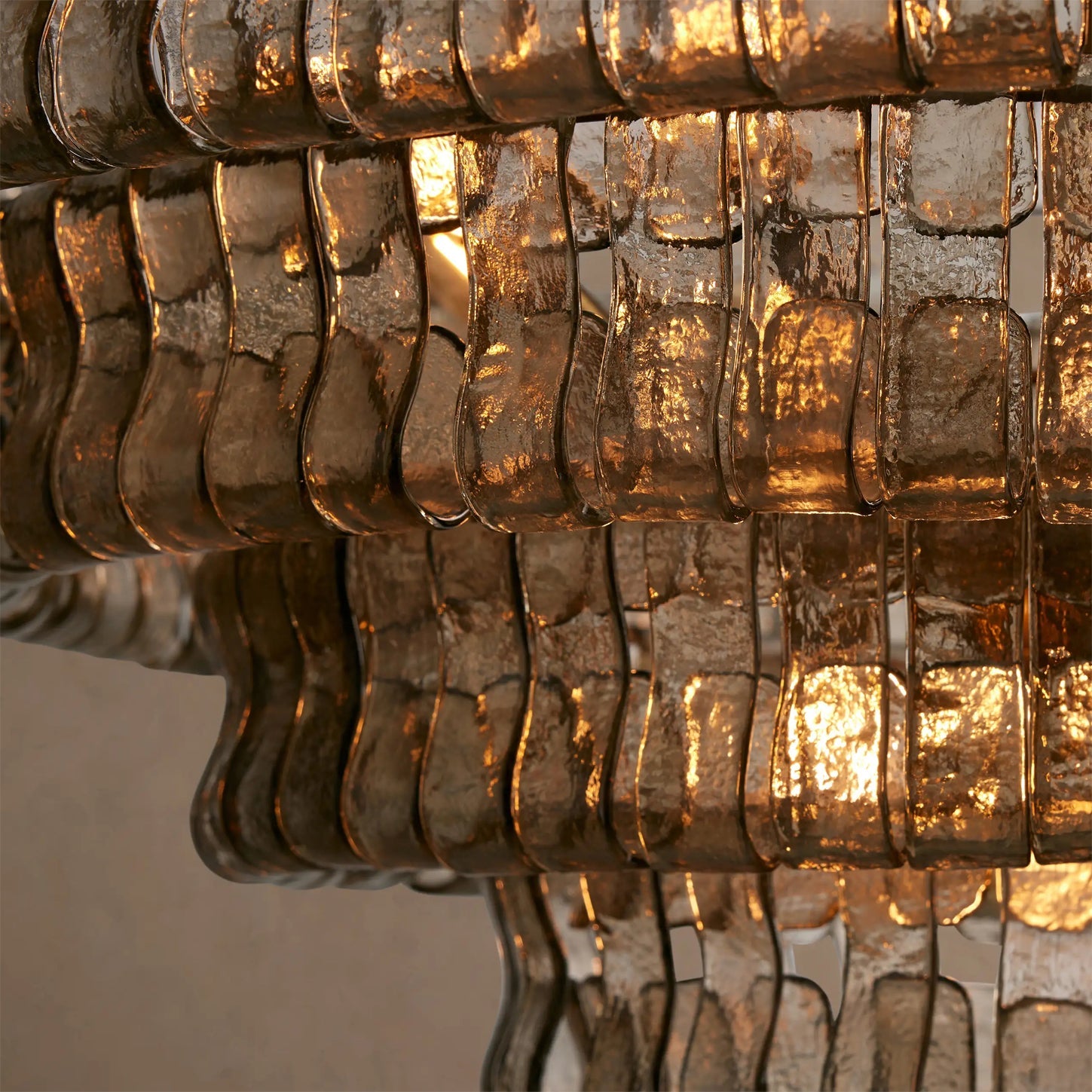 Close-up of a textured glass chandelier with warm lighting.