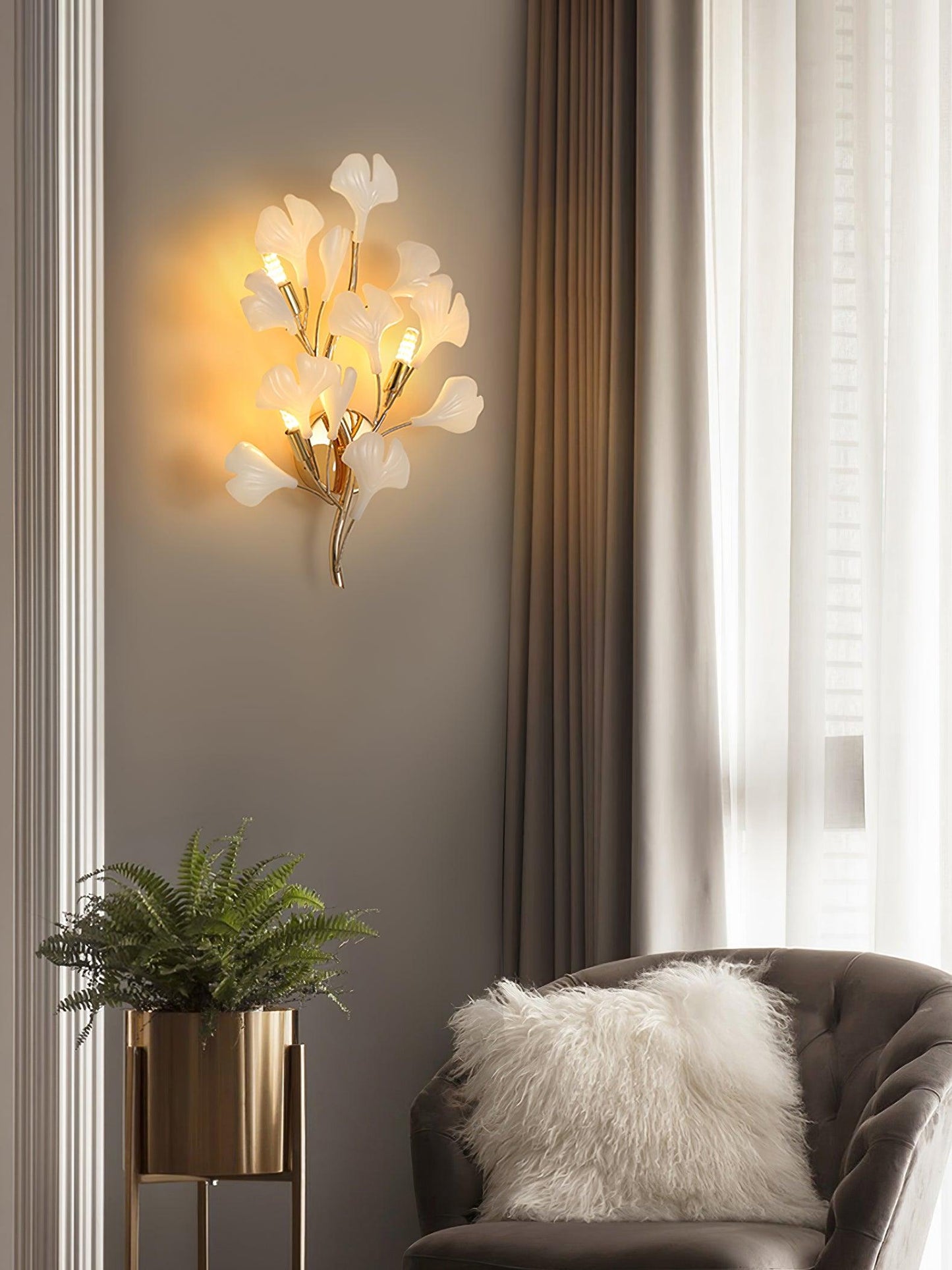 Modern wall light fixture in a living room setting with a plant and sofa.