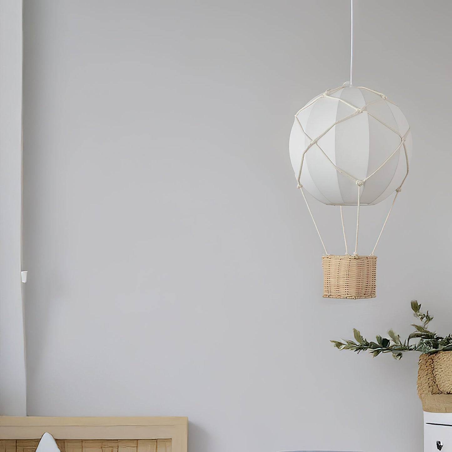Geometric pendant light with wicker basket against a plain wall