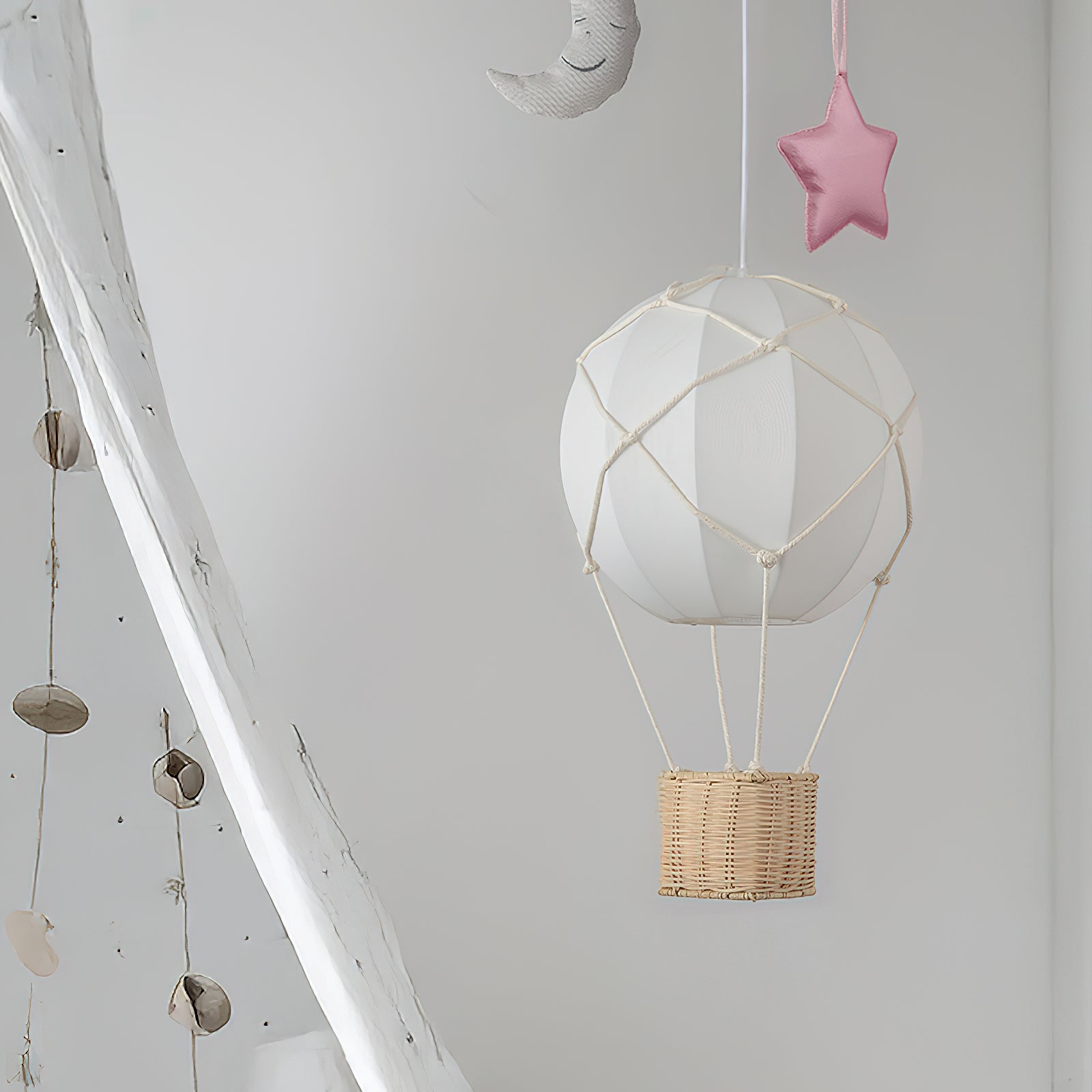 White hot air balloon with wicker basket hanging from a ceiling