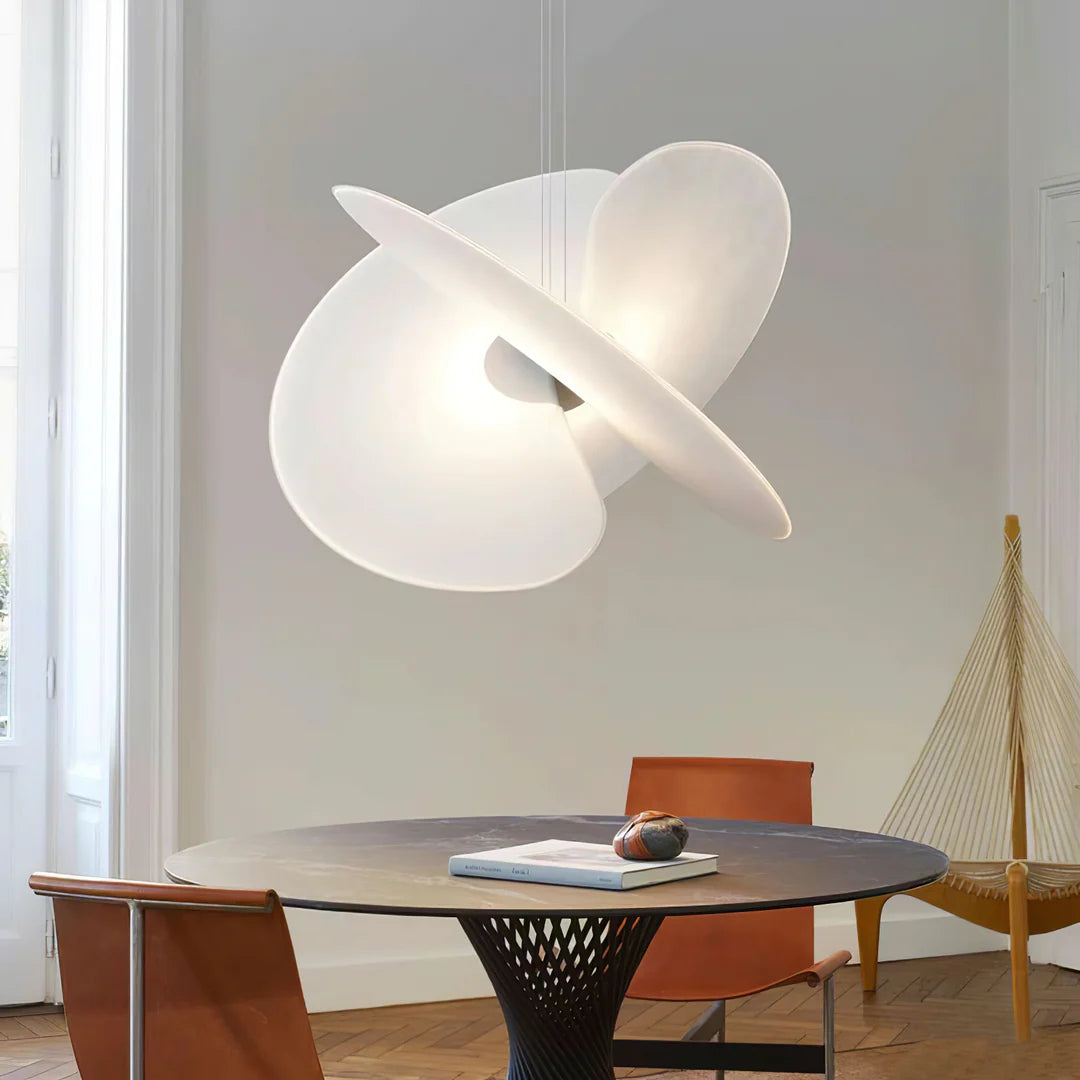 Modern white ceiling lamp in a room with a round table and chairs.