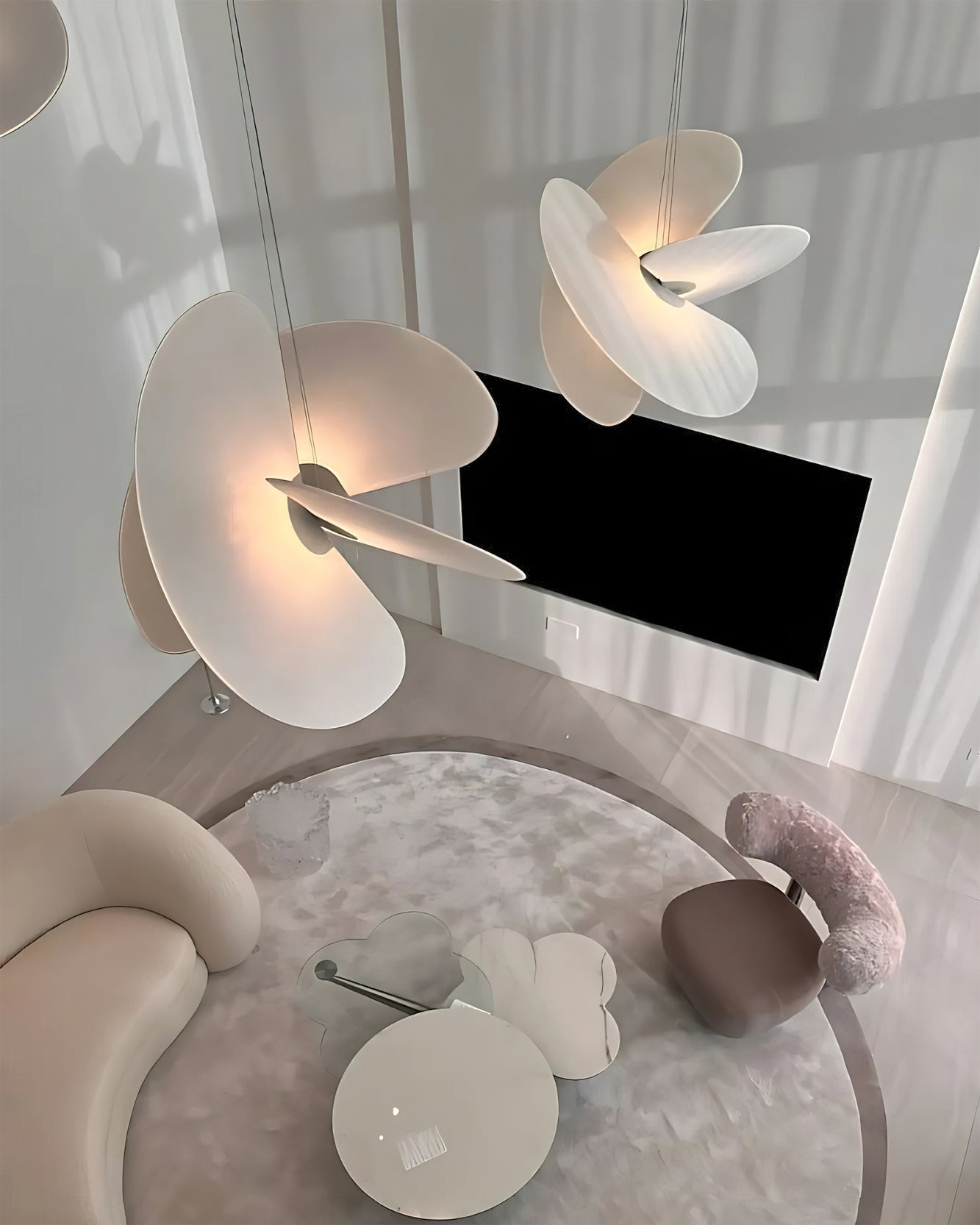 Modern interior with floral pendant lights, a round glass table, and decorative items.