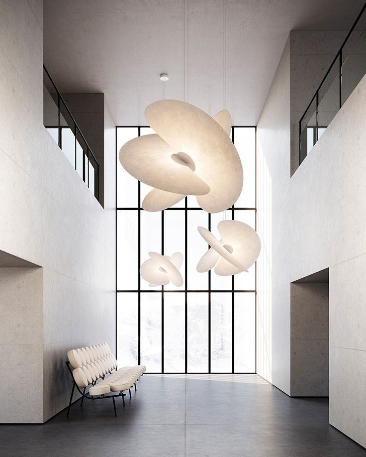 Modern interior with white abstract pendant lights and a chair near a large window.