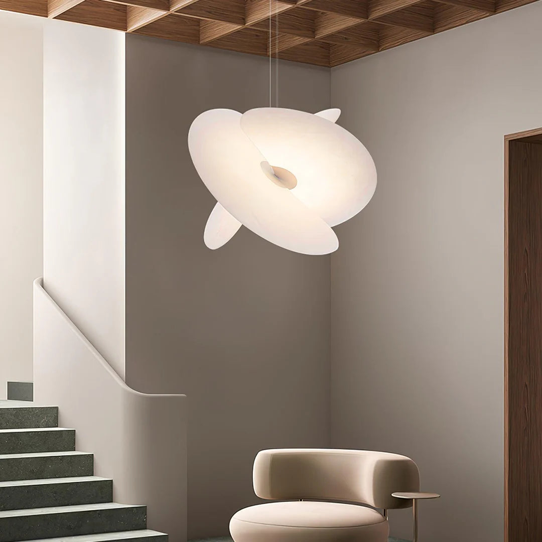 Modern pendant light hanging in a room with a staircase and chair.
