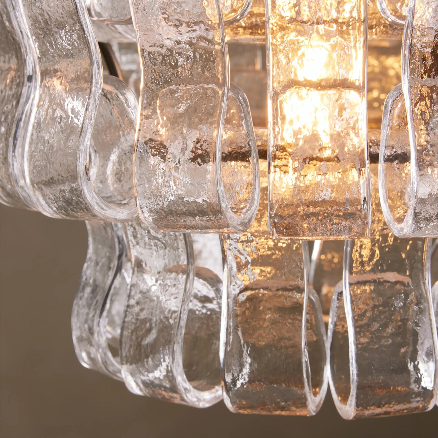 Close-up of a chandelier with clear glass shades and warm light.