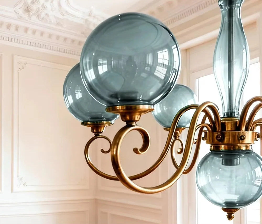 Blue glass globe shade and gold-tone arm on the Yuri Chandelier