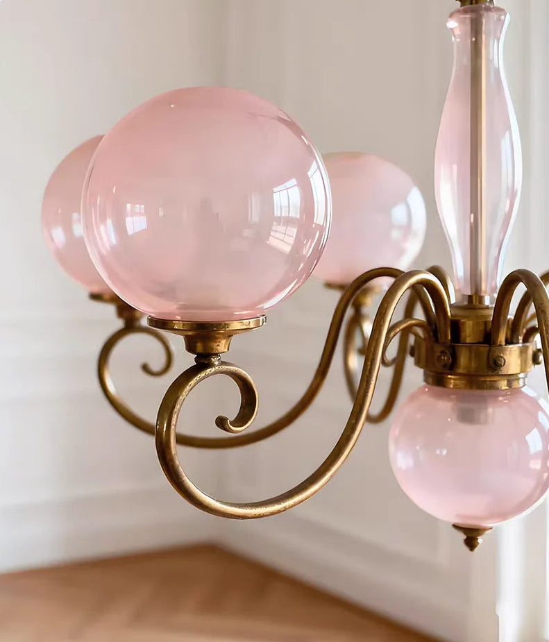 Close-up of Yuri pink glass shade and gold-tone scrollwork