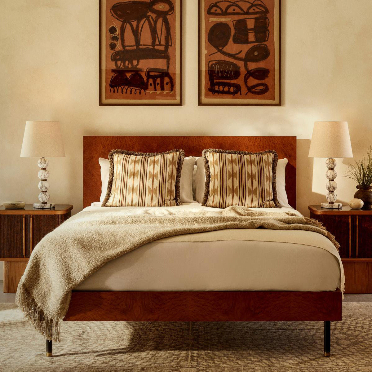 Bedroom with wooden bed, beige bedding, and decorative wall art.