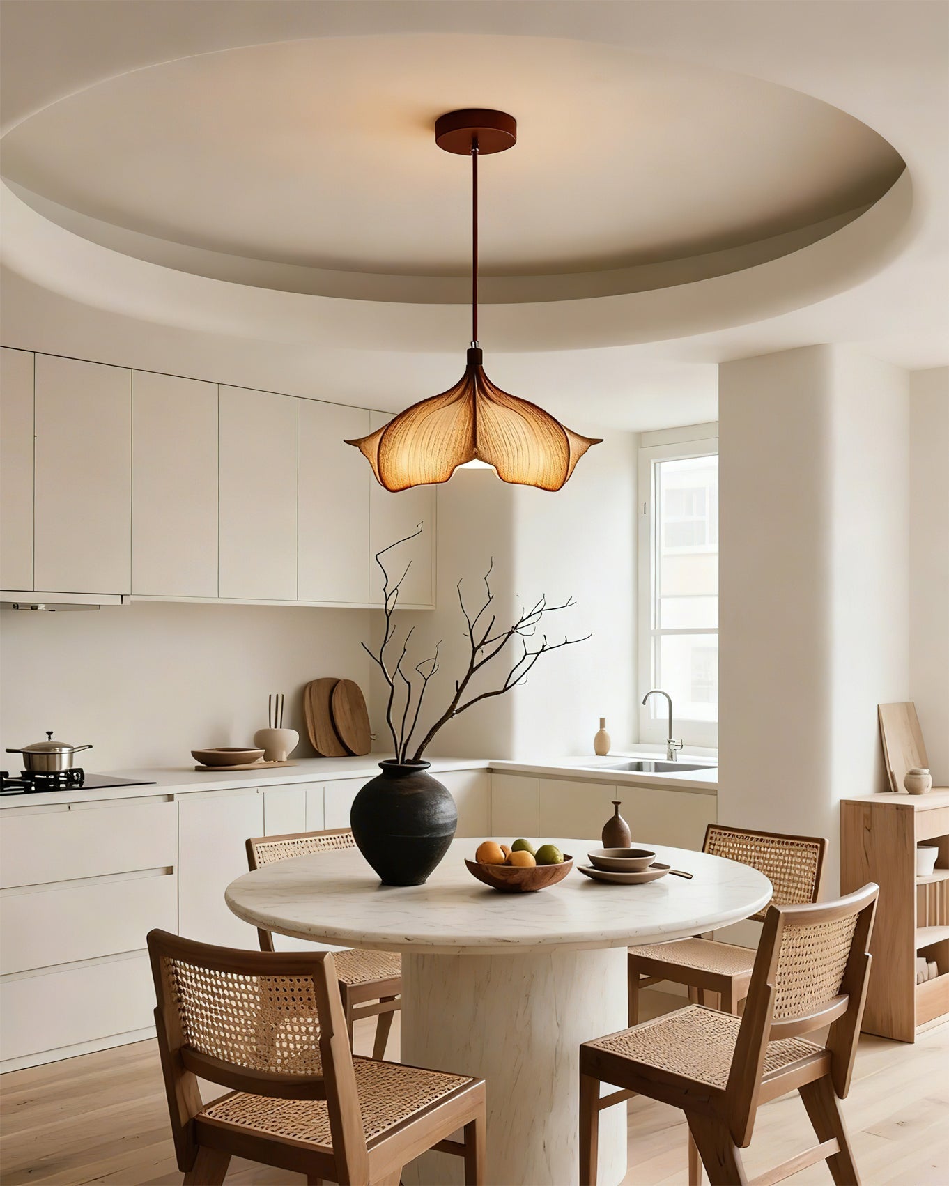 Modern kitchen with a round dining table and pendant light fixture.