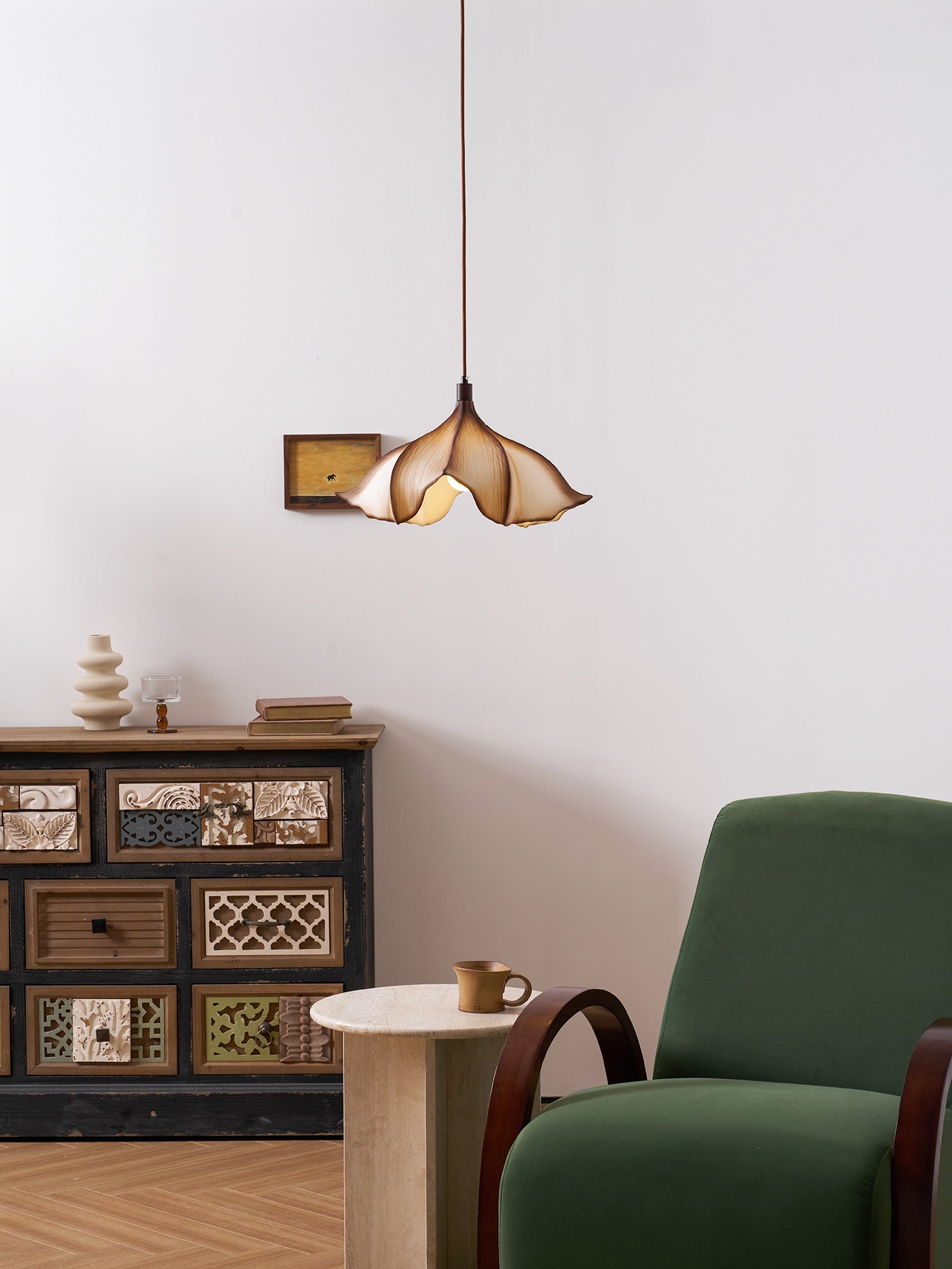 Modern interior with a green armchair, wooden cabinet, and pendant light.