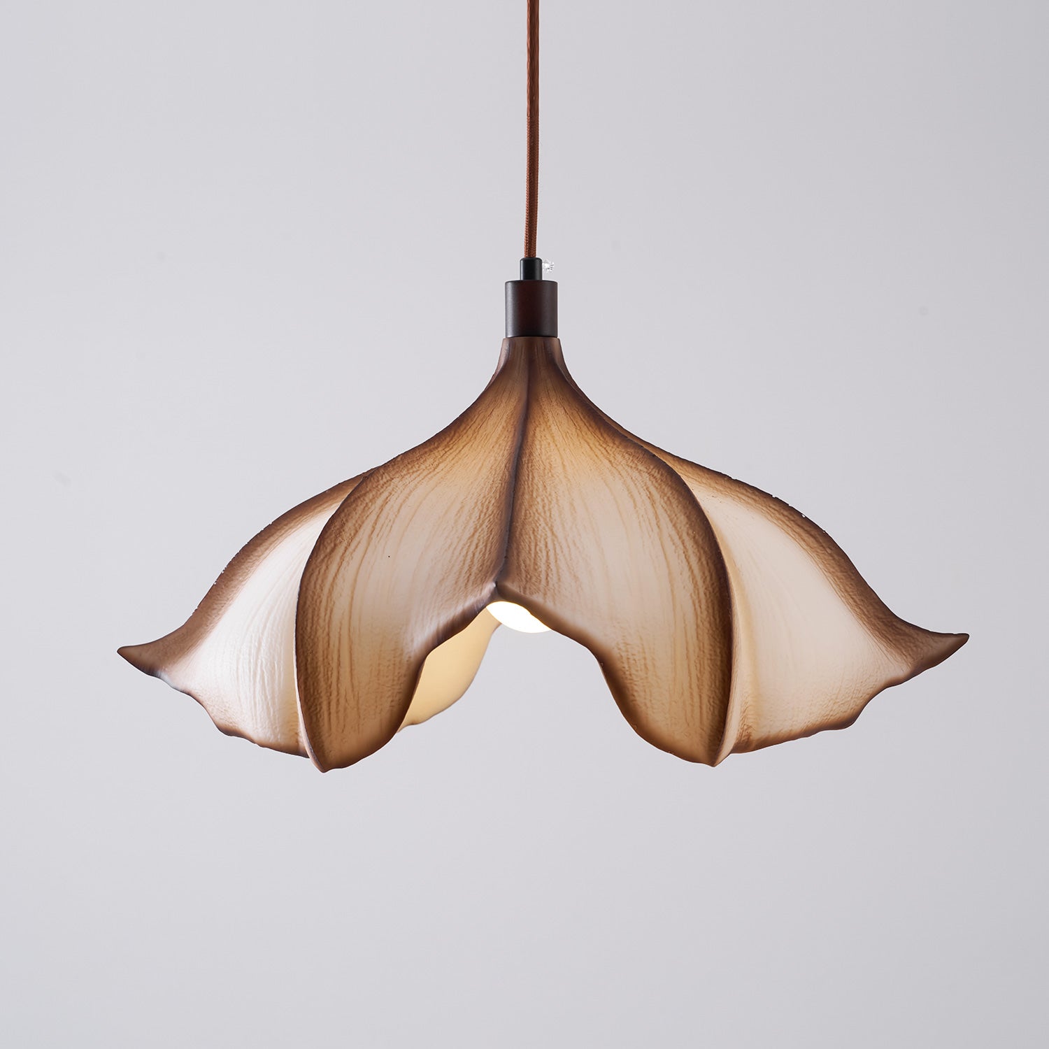 Floral-shaped pendant light with a beige and brown design on a gray background
