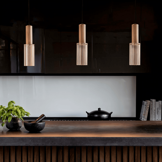 Modern kitchen with pendant lights, black backsplash, and wooden countertop.